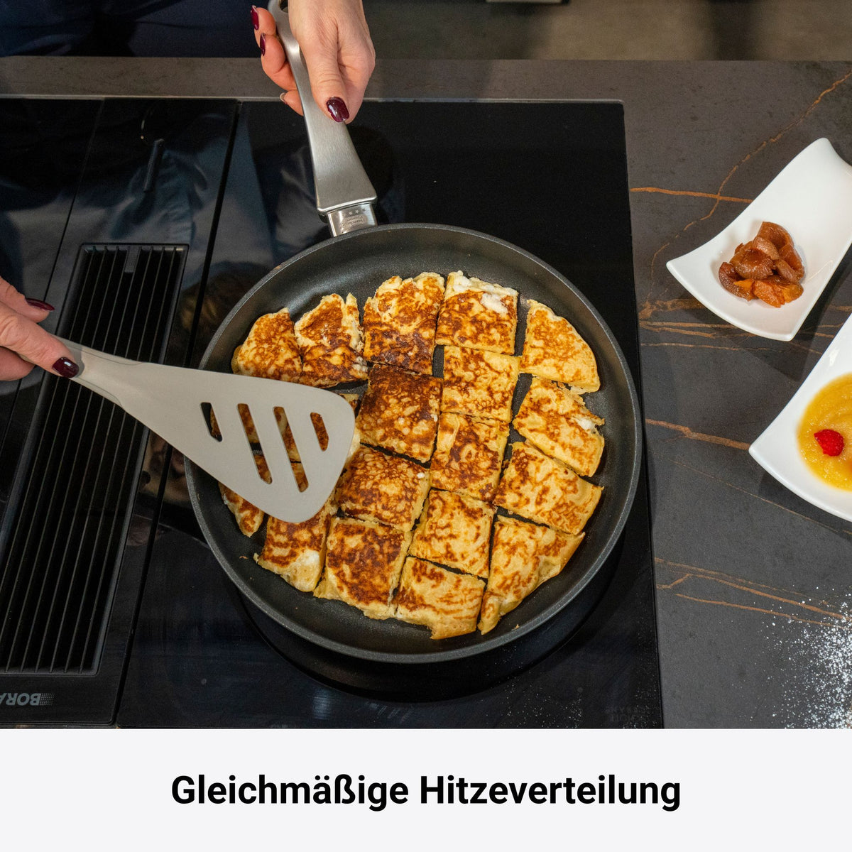 Bratpfanne mit goldbraun gebratenem, in Stücke geschnittenem Pfannkuchen auf Herd.