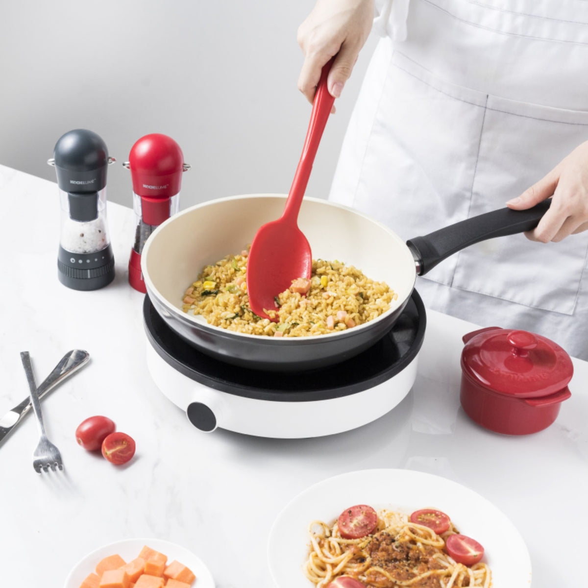 Roter Soßenlöffel aus Silikon mit schwarzem Griff beim Rühren in Pfanne.