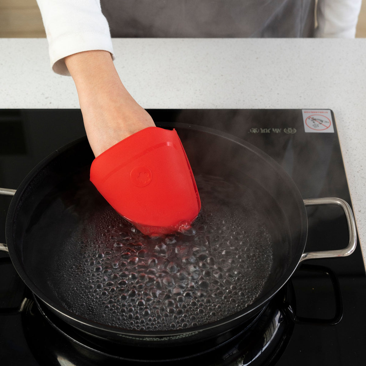 Roter Thermo-Fingerschutz hält Finger beim Greifen heißer Töpfe sicher geschützt.