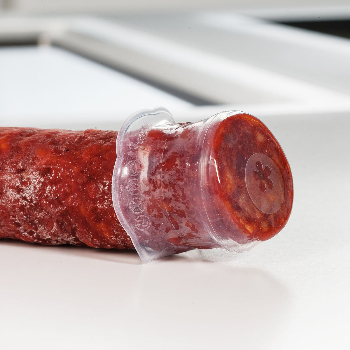 Oranger transparenter Verschluss aus flexiblem Material auf Salamiende.