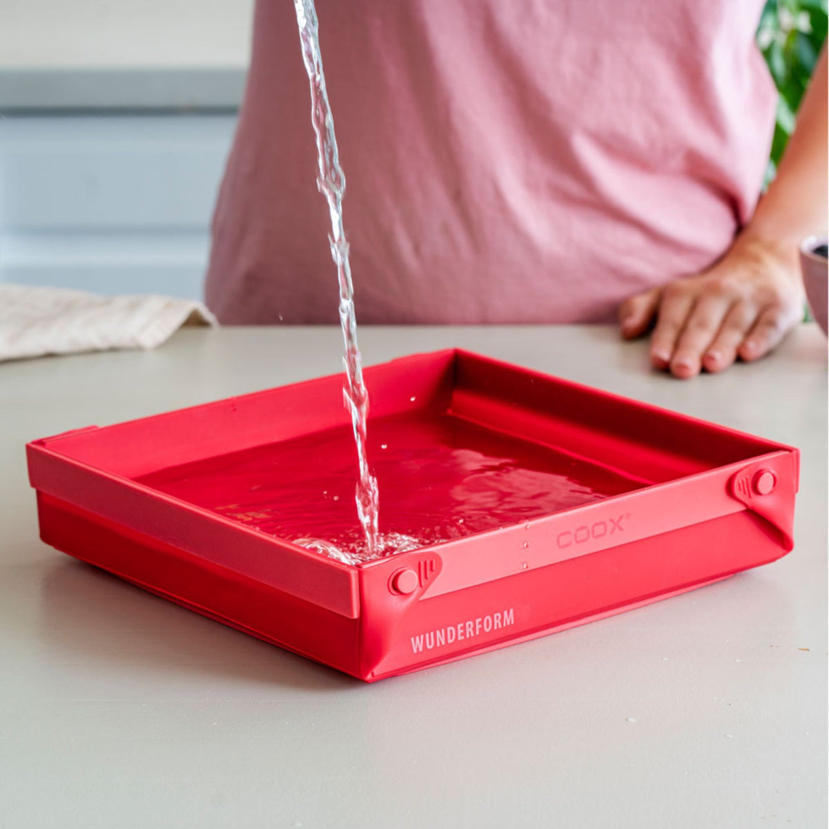 Rote quadratische Pfanne aus Silikon mit hohem Rand und glatter Oberfläche.