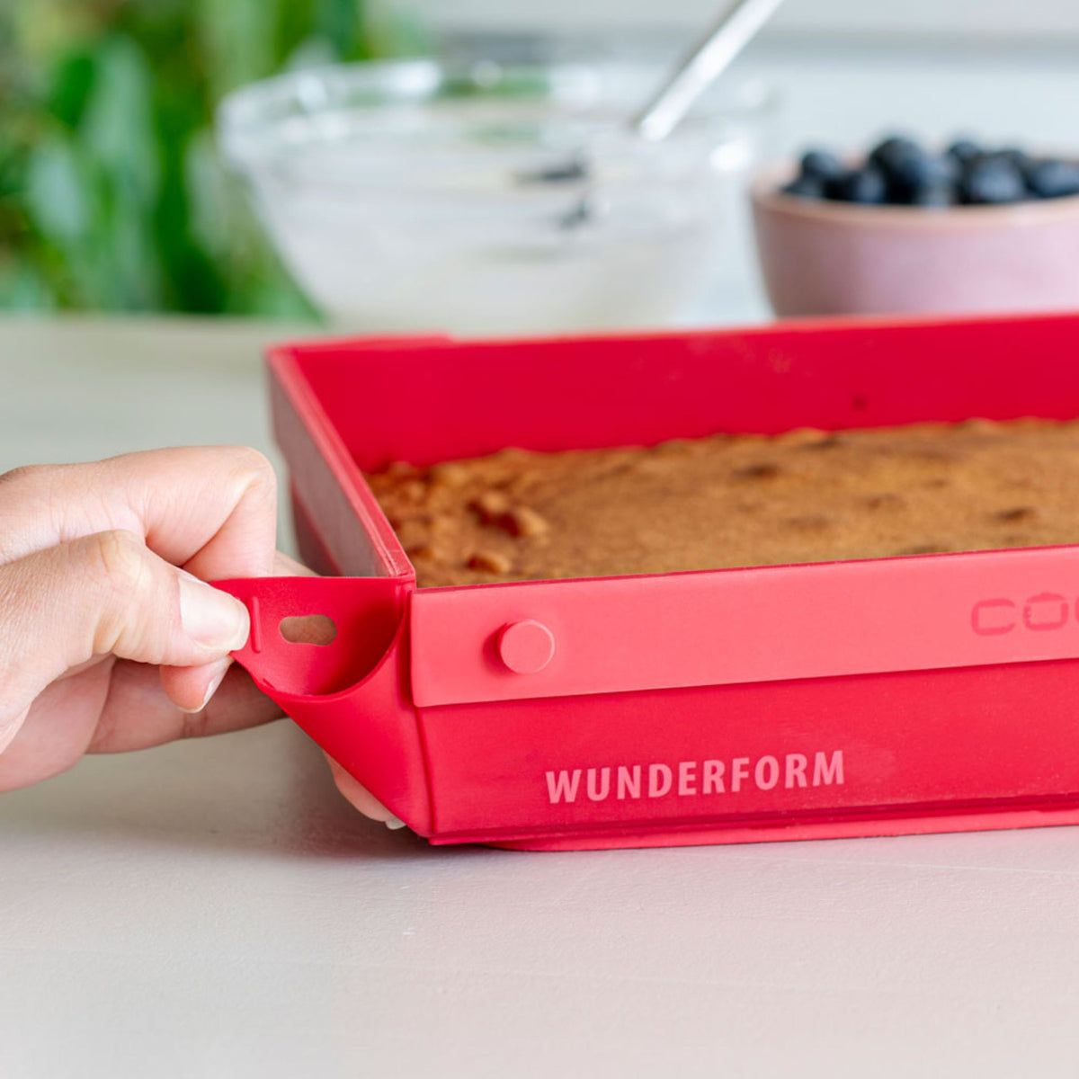 Rote, quadratische Backform aus flexiblem Silikon mit Griff und Schriftzug "Wunderform".