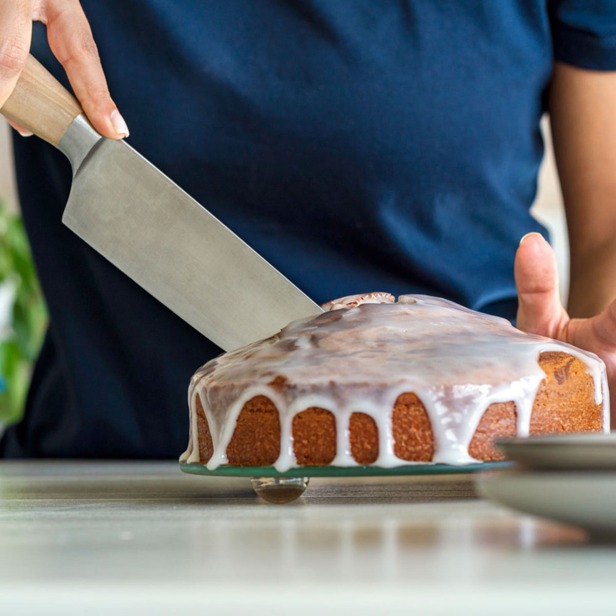 Runder Kuchen auf blauem Coox Springform mit abnehmbarem Rand und Holzgriff.
