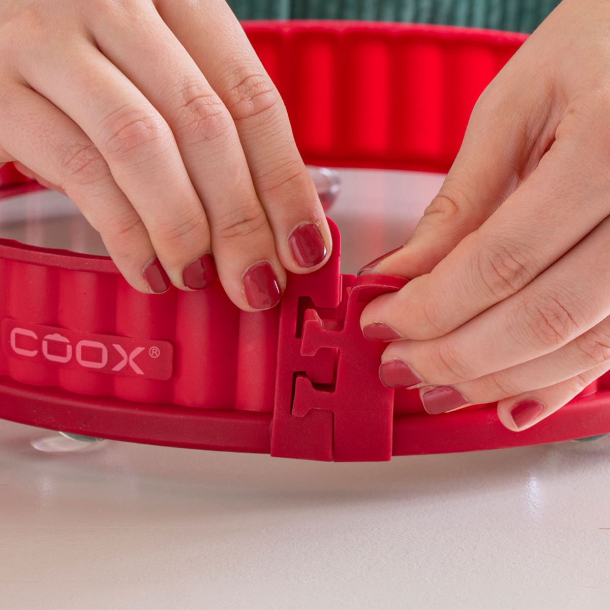 Rote Coox Quicheform mit abnehmbarem Verschluss und welligem Rand aus Metall.